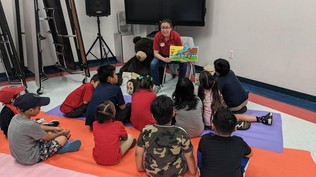 Staff member from the Houston Library reading a book to the students